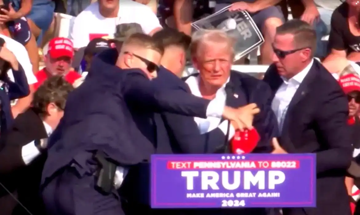 O candidato presidencial republicano e ex-presidente dos EUA, Donald Trump, é auxiliado por pessoal de segurança após o tiroteio durante um comício de campanha no Butler Farm Show em Butler, Pensilvânia, EUA. crédito- REUTERS/ TV© crédito- REUTERS/ TV